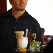 Photograph of waiter carrying tray of cocktails